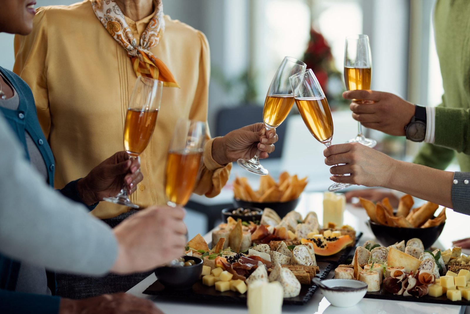 Close-up of business colleagues toasting with Champagne while having a party in the office.